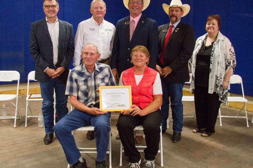Kochis Farms members hold their Centennial Farms certificate while state officials stand behind them.