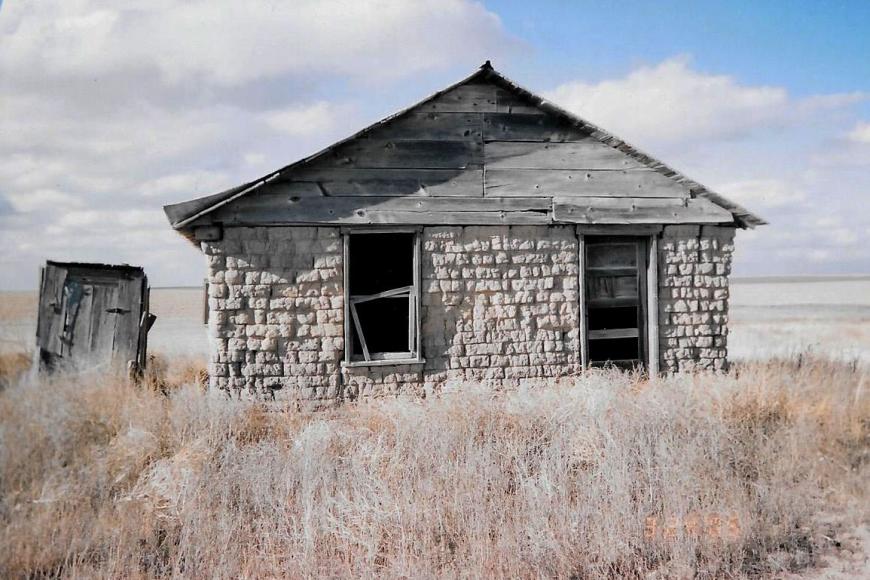 An abandoned sod house and privy stand on the Coe Homestead.