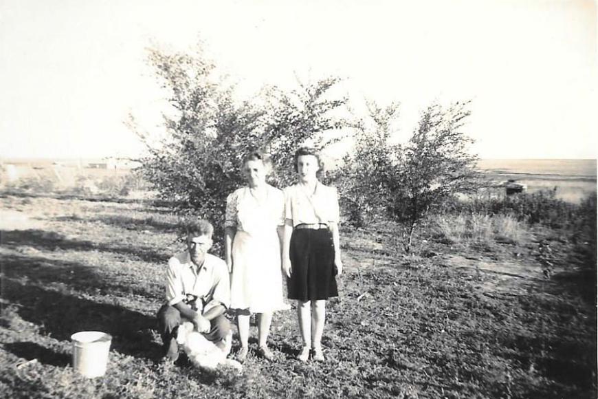Two women and a man pose for the photographer on the Coe Homestead.