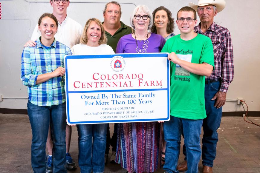 McCracken Farms family with their Centennial Farm sign.