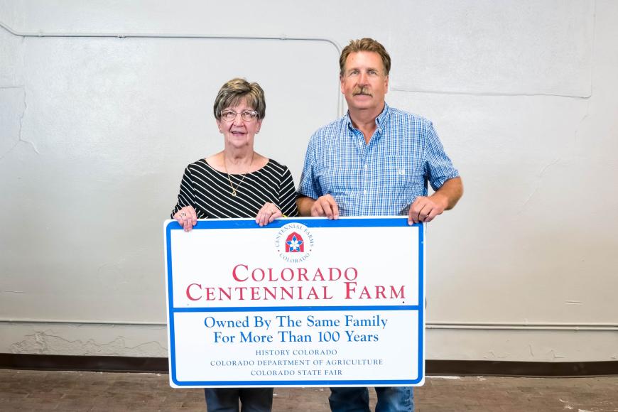 Members of the Coe family with their Centennial Farms sign.