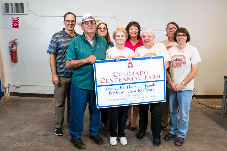 Members of the Ugolini Farm Dairy family with their sign.