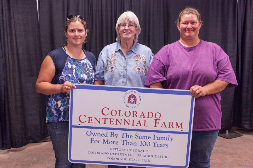 Members of the Knoblauch family with their Centennial Farm sign.