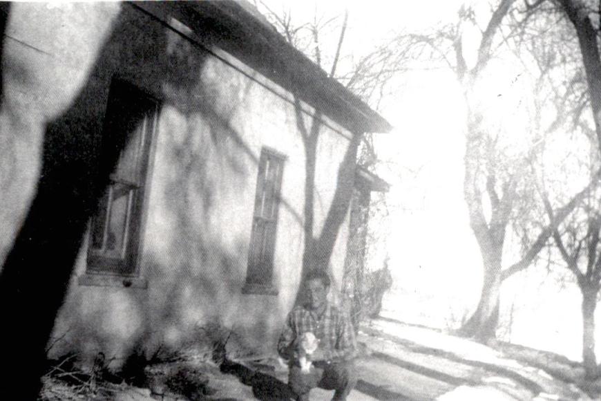 Historic photo showing a young John Koch outside the 1914 farmhouse with "Old Tom".
