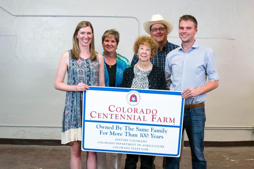 Members of the Peppler family, descendants of Fred Muhme, with their Centennial Farms sign.