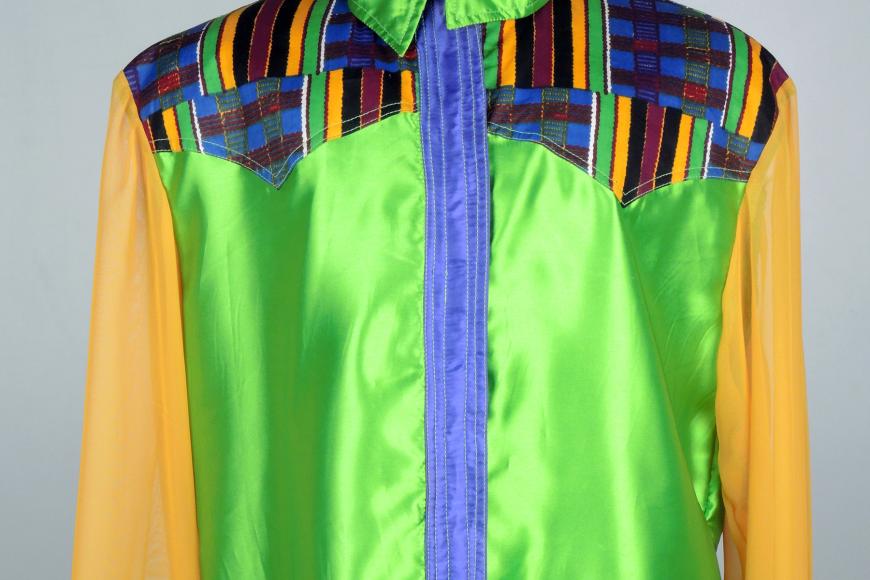 A colorful rodeo shirt on display. It is made of a very reflective material, and is very colorful.