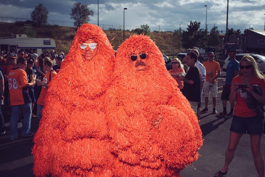 2 Broncos Superfans, the Mile High Monsters, wearing orange pom pom costumes