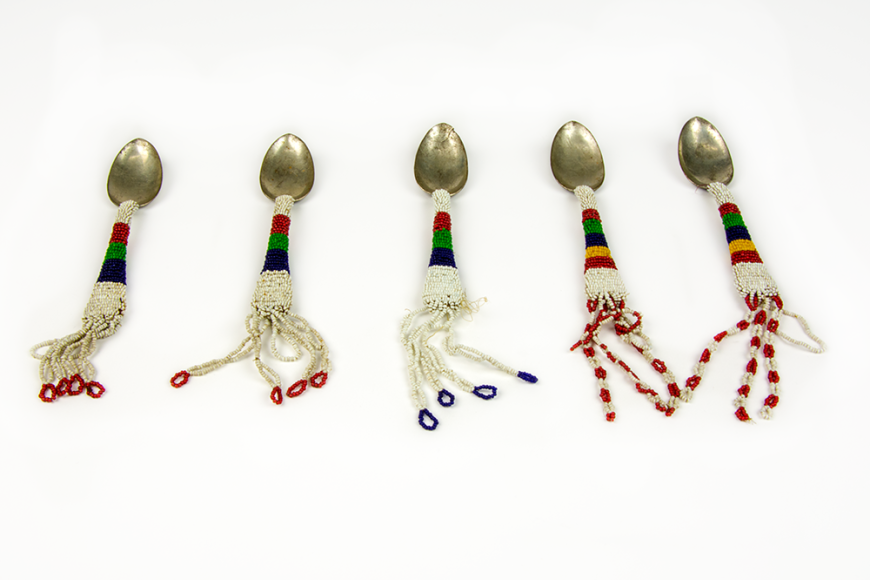 5 spoons . The handles are beaded with white, blue, green, red, and yellow beans. Each spoon has a few beaded tassels coming off each end.