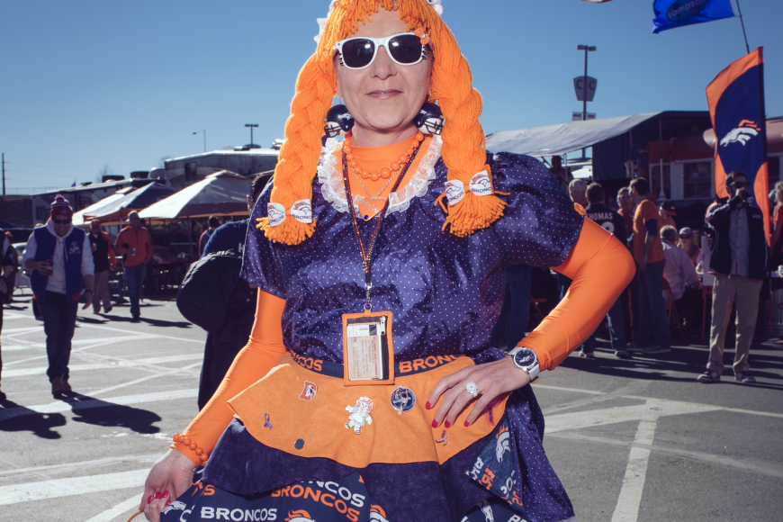 Bronco superfan in a orange yarn wig and german inspired Broncos dress.