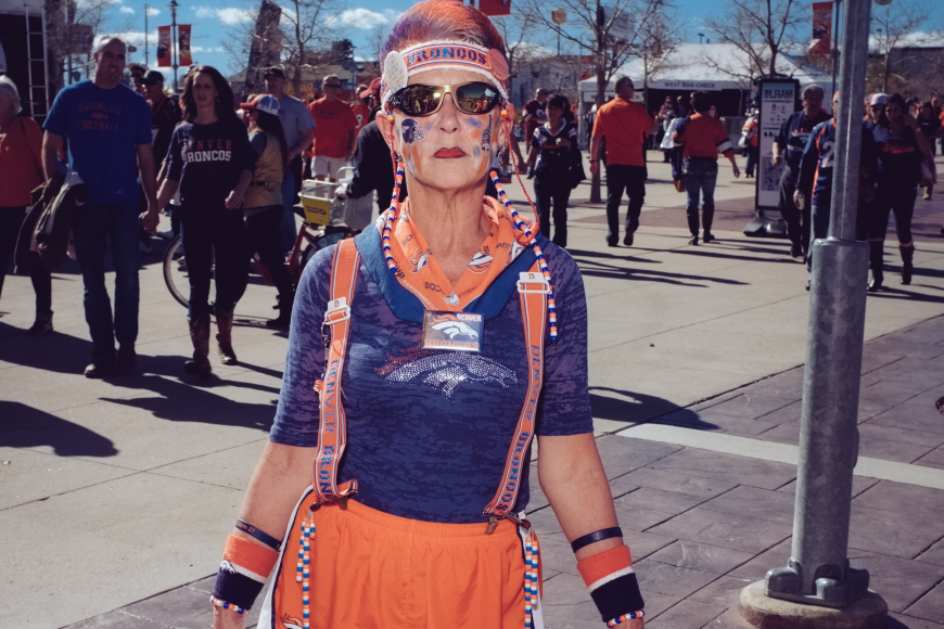 A bronco superfan with orange suspenders, mohawk, and Broncos war paint