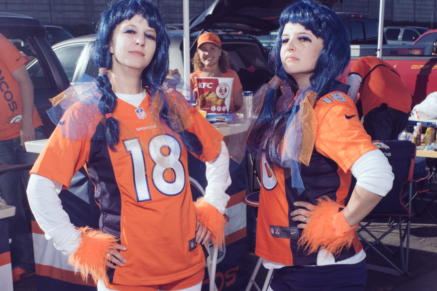 2 broncos superfans in jerseys and long blue wigs