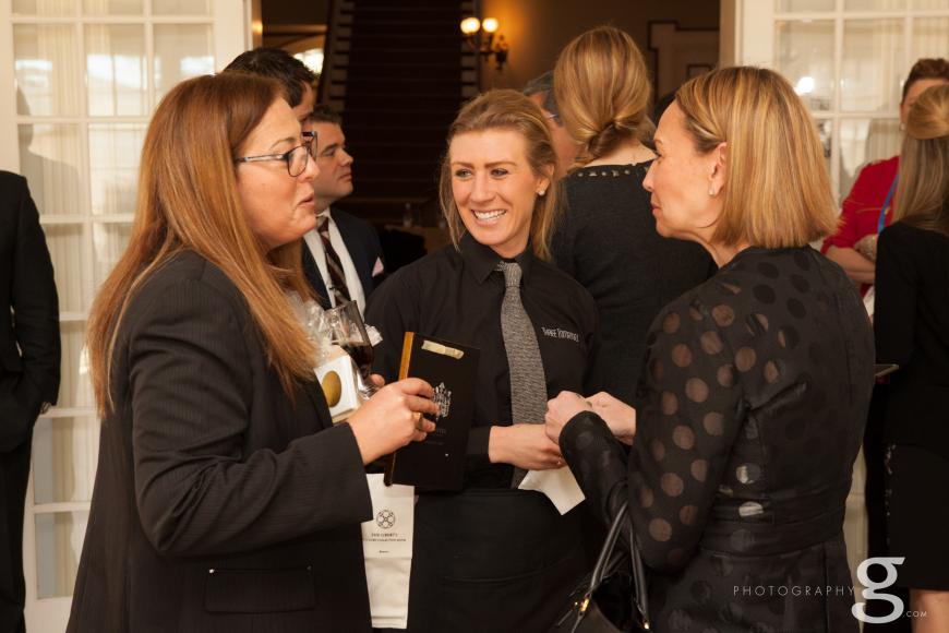 3 women in black suits chat happily at an event at Grant-Humphreys
