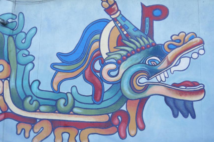 Closeup mural of quetzalcoatl in green, blue, yellow, and red.