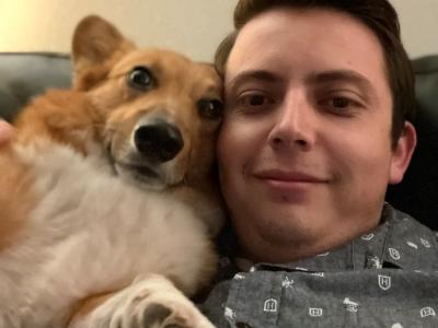 Photo of a tan and white Pembroke Welsh Corgi named Winston. He is pictured here in a selfie with his owner, their heads together and they are both smiling! 