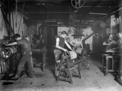 Men working with type on rollers in the printing room of the Rocky Mountain News, 1900s-1910s.