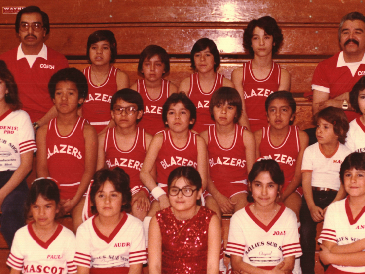 Color photograph of Eastwood Heights basketball team, cheer squad, and coaches; pictured wearing uniforms and sitting on bleachers in gym in Dog Patch, CO.