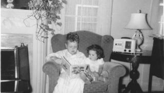 Ten-year-old Dick Rogers reading to his two-year-old sister, Donna, in their Denver home, June 1950. History Colorado. 2020.36.71