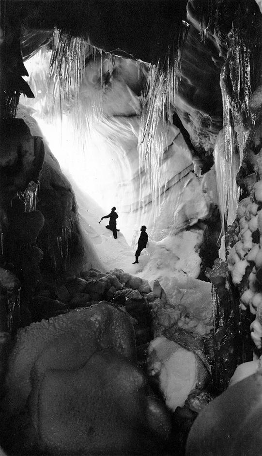 Two people pose in cave at Hawlett (Rowe) Glacier in Rocky Mountain National Park