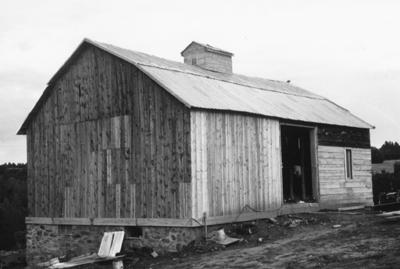 Black-and-white image of a bank barn.
