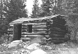 Round log, saddle-notched, side-gabled cabin in Boulder County.