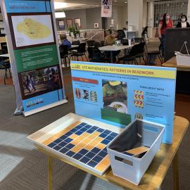 A pop up panel and interactive exhibit on display in a public space at a community college building.