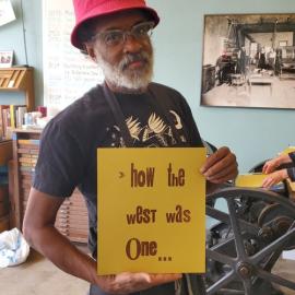 Chip Thomas holding a sign reading "How the West was Won"